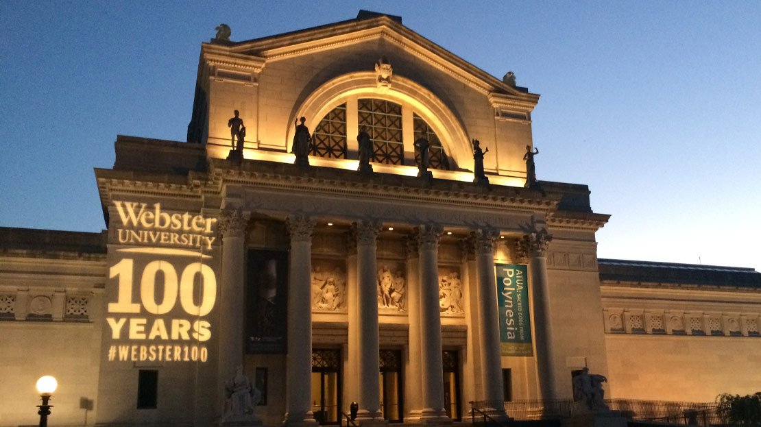 The Saint Louis Art Museum illuminated at night with "51СƳ 100 Years" shining on the building.